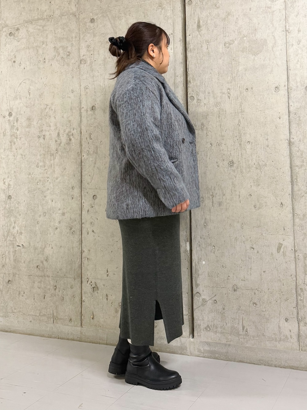 グレー系のその他アウター、ブラック系のブーツ、グレー系のワンピースを着用したレディースの冬コーディネートの2枚目の写真