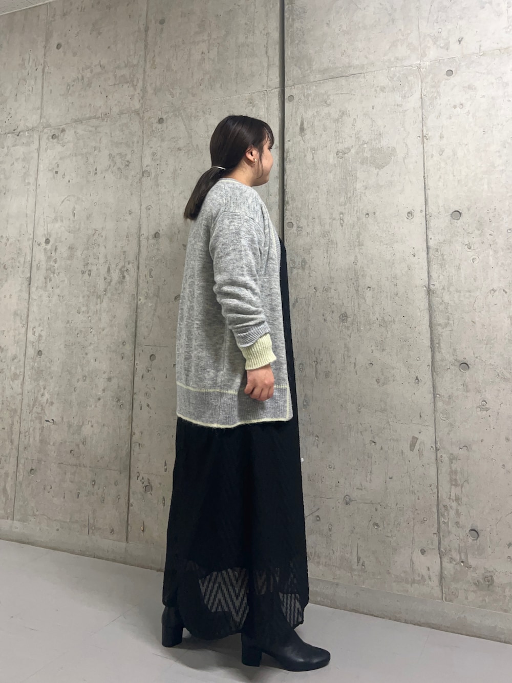 ブラック系のワンピース、ブラック系のブーツ、グレー系のカーディガン/ボレロを着用したレディースの秋コーディネートの3枚目の写真