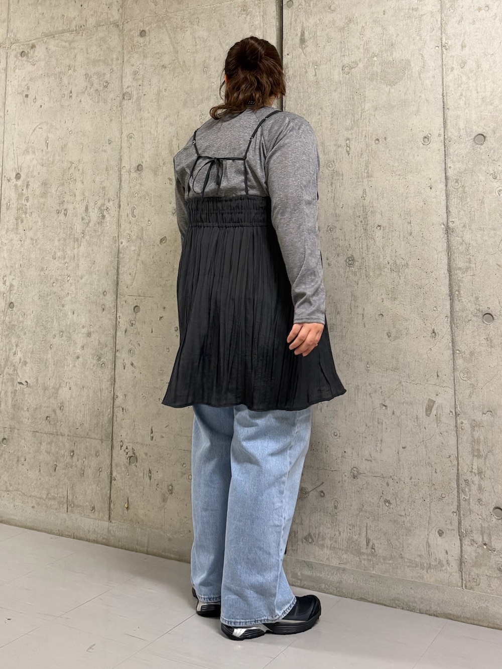 グレー系のTシャツ/カットソー、グレー系のワンピース、ブルー系のデニムパンツを着用したレディースの春コーディネートの2枚目の写真