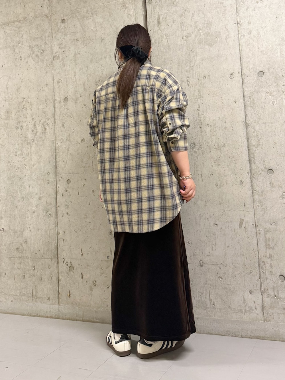 イエロー系のシャツ/ブラウス、ブラウン系のスカートを着用したレディースの冬コーディネートの2枚目の写真