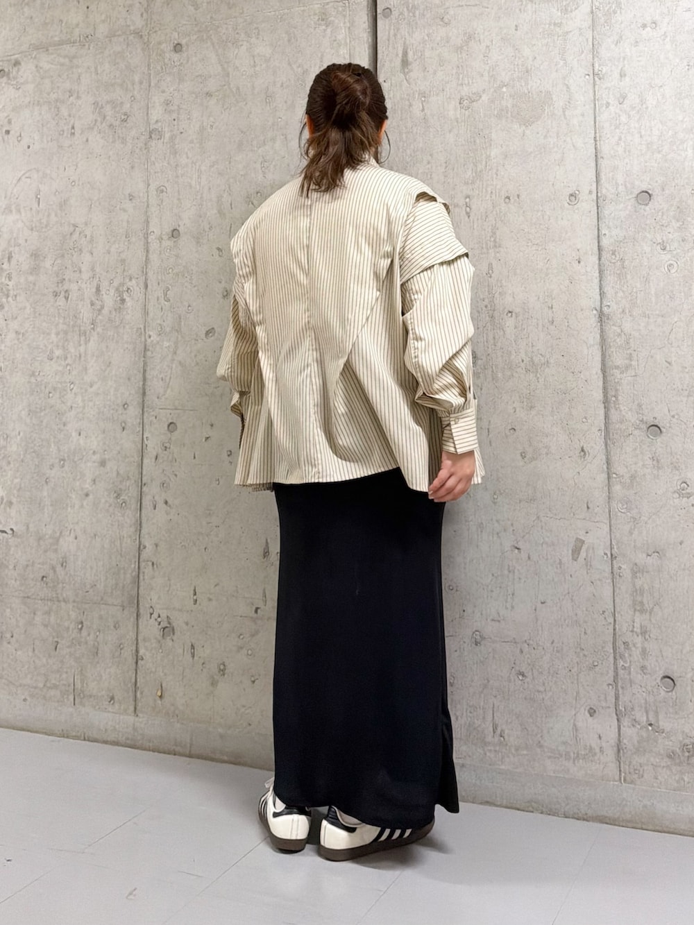 ベージュ系のシャツ/ブラウス、ブラック系のスカートを着用したレディースの冬コーディネートの3枚目の写真