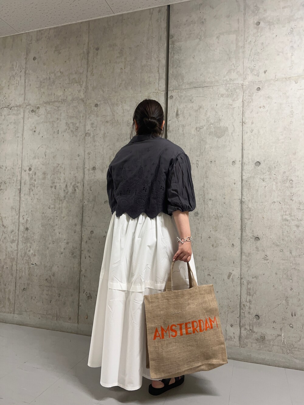 グレー系のシャツ/ブラウス、ベージュ系のバッグ、ホワイト系のスカートを着用したレディースの夏コーディネートの2枚目の写真