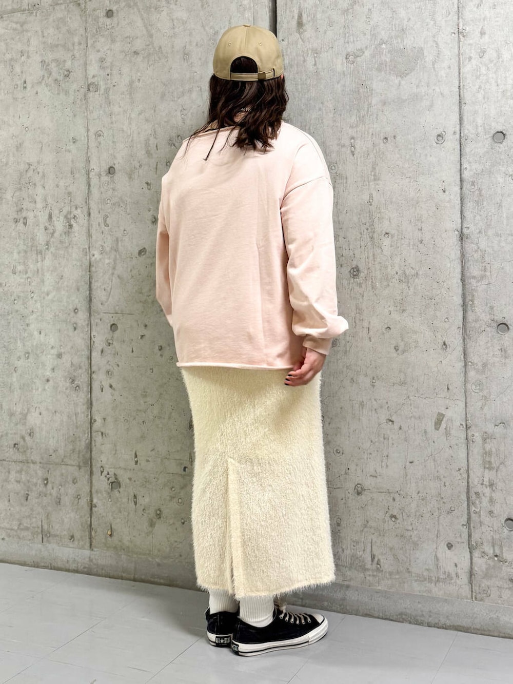 ホワイト系のスカート、ピンク系のスウェット、シルバー系のネックレスを着用したレディースの冬コーディネートの2枚目の写真