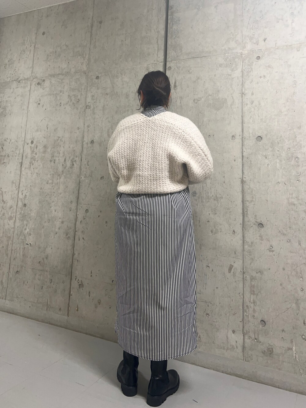 ベージュ系のカーディガン/ボレロ、ホワイト系のワンピース、ブラック系のブーツを着用したレディースの秋コーディネートの3枚目の写真