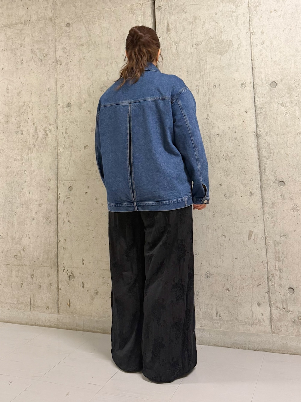 ブルー系のブルゾン、ブラック系のその他パンツを着用したレディースの春コーディネートの3枚目の写真