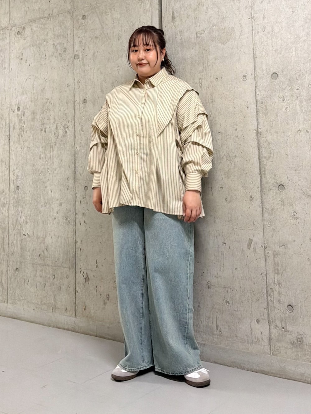 ブラック系のブルゾン、ベージュ系のシャツ/ブラウス、ブルー系のデニムパンツを着用したレディースの春コーディネートの2枚目の写真