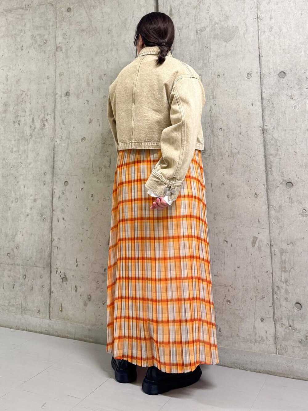 ベージュ系のデニムジャケット、ブラック系のその他シューズ、オレンジ系のスカートを着用したレディースの春コーディネートの2枚目の写真