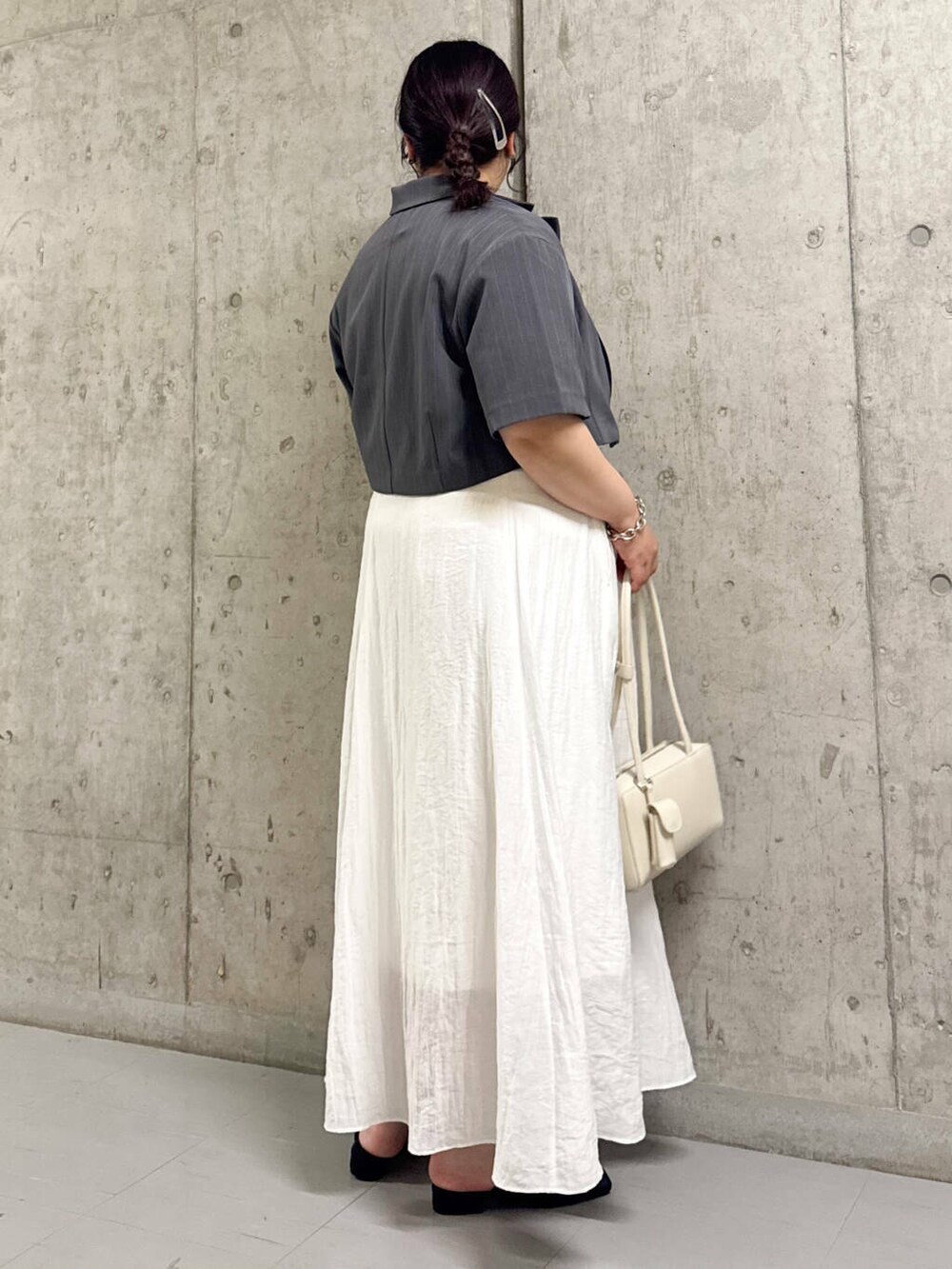 ブラック系のサンダル、ホワイト系のショルダーバッグ、ホワイト系のスカートを着用したレディースの夏コーディネートの2枚目の写真