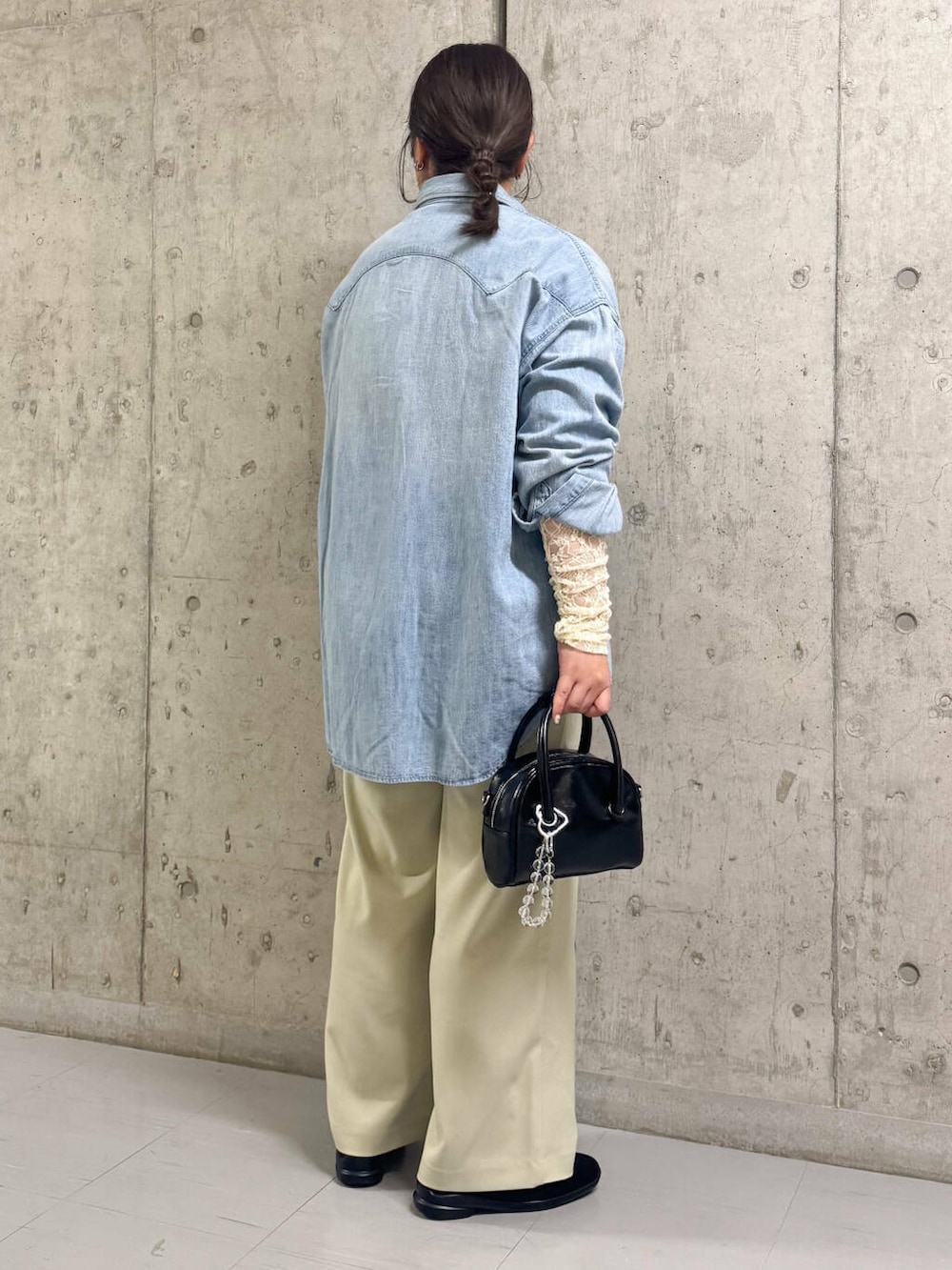ブラック系のボストンバッグ、ブルー系のシャツ/ブラウス、ベージュ系のその他パンツを着用したレディースの春コーディネートの3枚目の写真