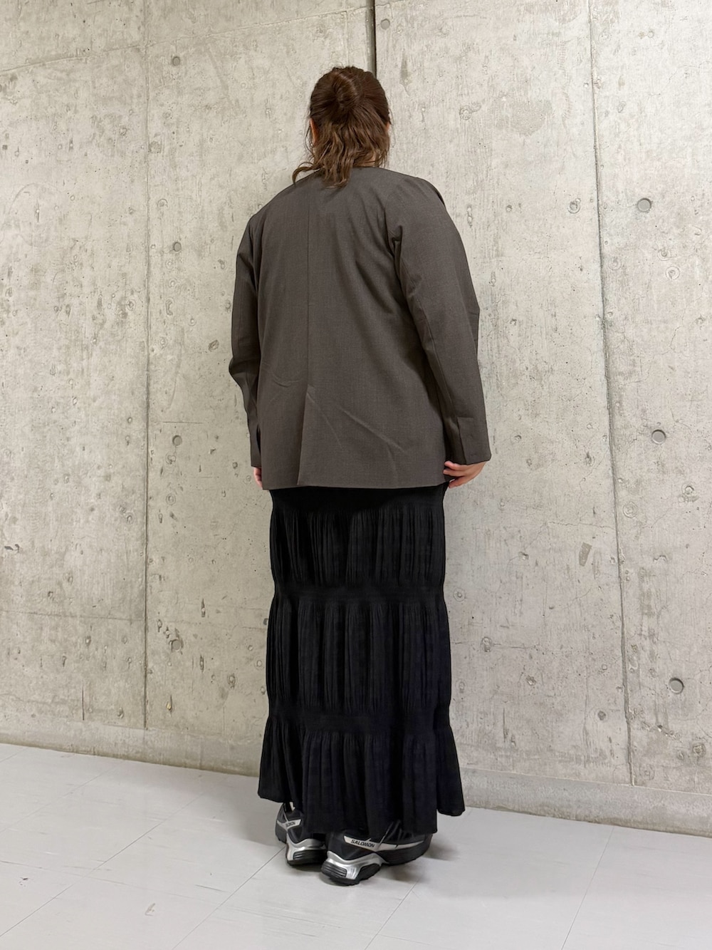 ブラック系のセットアップ、ブラウン系のノーカラージャケット、ベージュ系のタンクトップを着用したレディースの春コーディネートの3枚目の写真