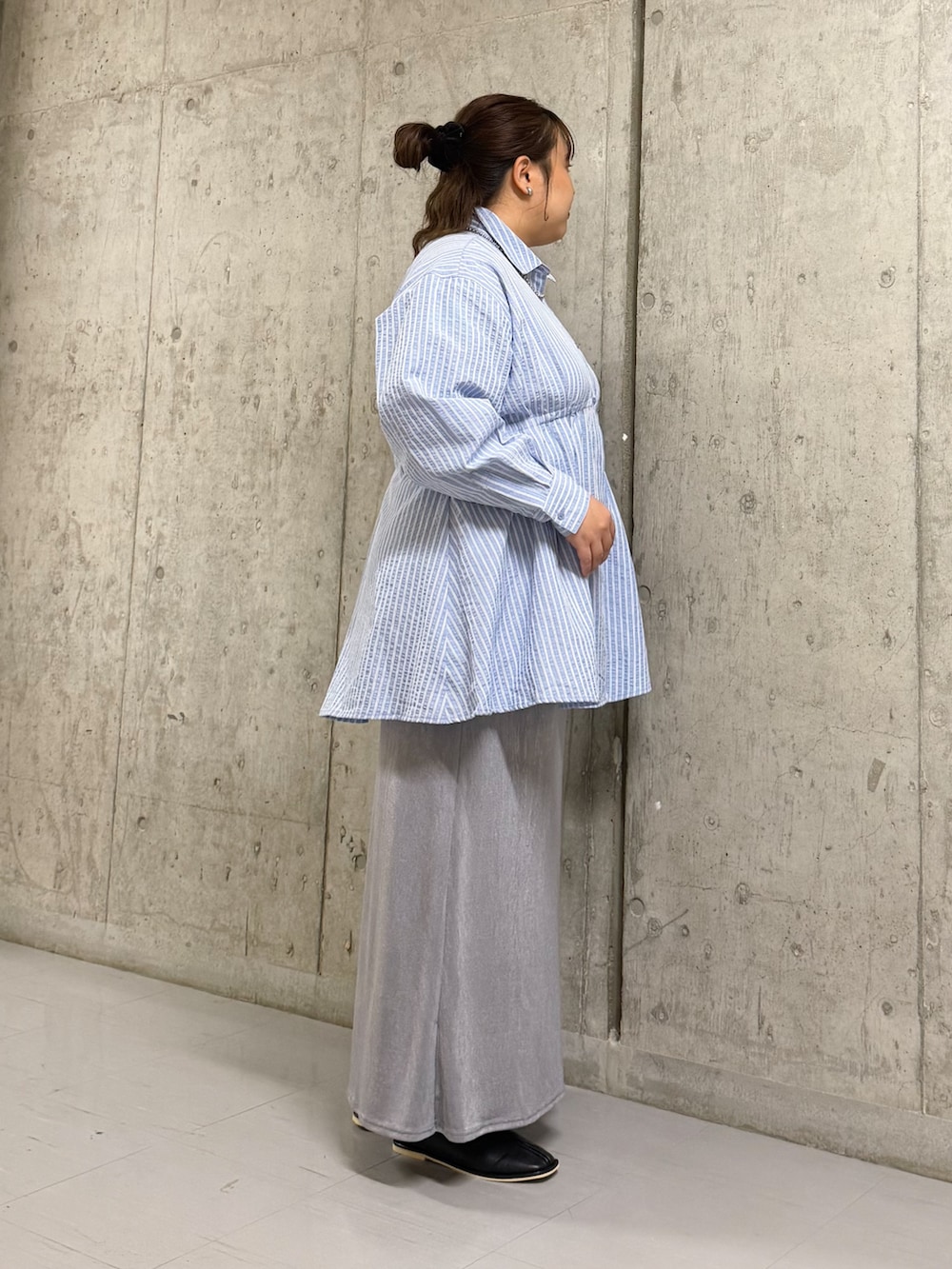 ブルー系のワンピース、グレー系のスカート、ブラック系のパンプスを着用したレディースの冬コーディネートの2枚目の写真