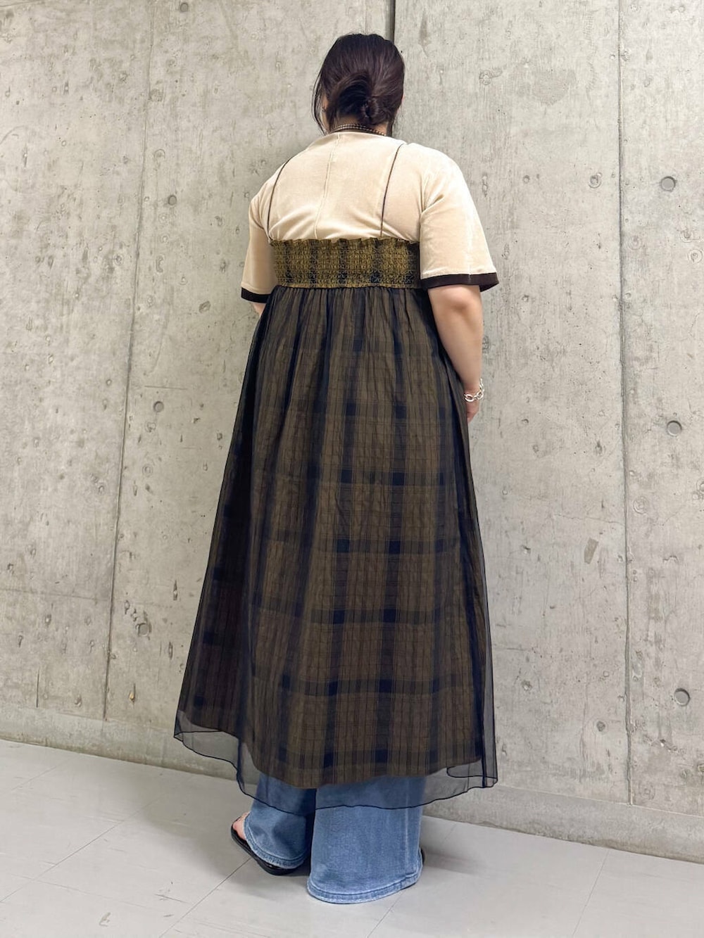 ブルー系のデニムパンツ、ベージュ系のTシャツ/カットソー、グリーン系のスカートを着用したレディースの夏コーディネートの3枚目の写真