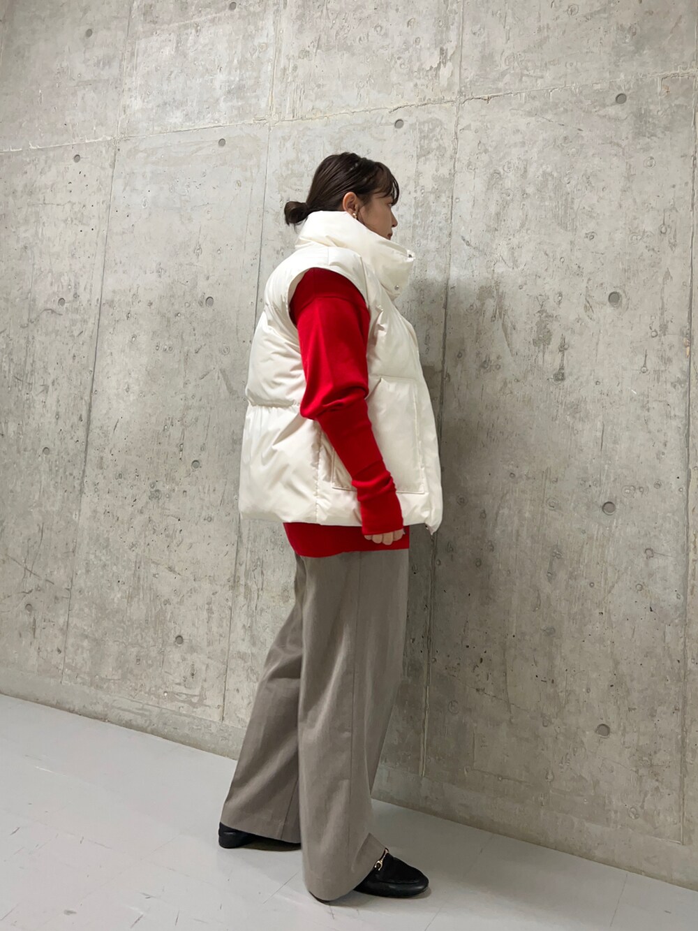 ブラウン系のスラックス、ホワイト系のダウンジャケット/コート、レッド系のニット/セーターを着用したレディースの秋コーディネートの3枚目の写真