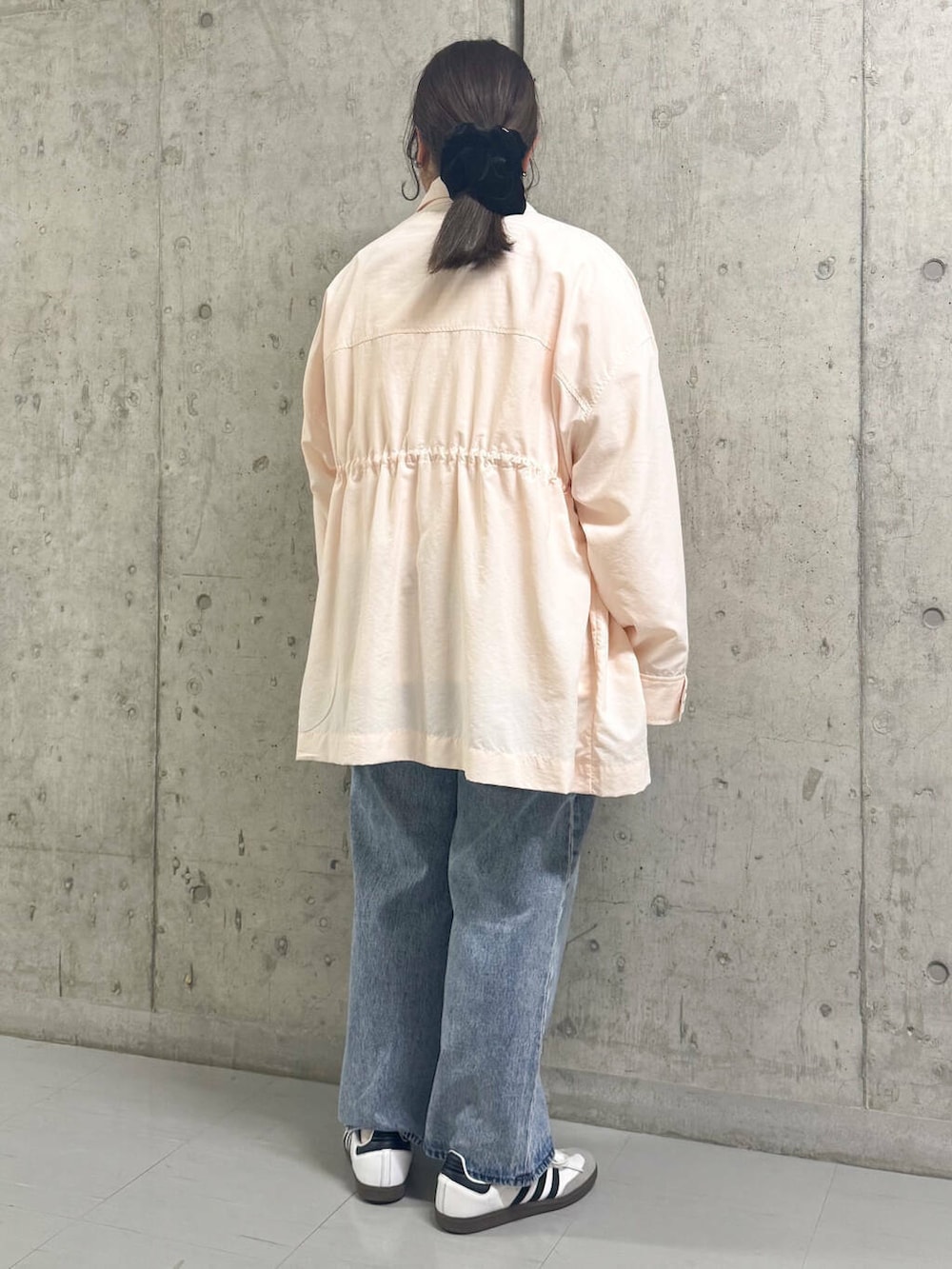 ブルー系のデニムパンツ、ピンク系のナイロンジャケット、ピンク系のTシャツ/カットソーを着用したレディースの春コーディネートの3枚目の写真