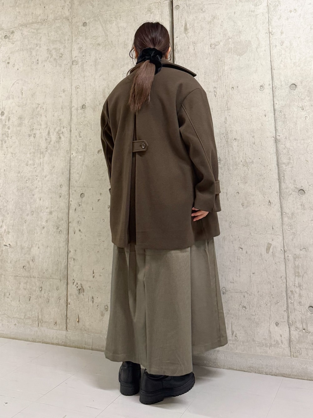 ブラウン系のその他アウター、レッド系のニット/セーター、ブラウン系のワンピースを着用したレディースの冬コーディネートの3枚目の写真