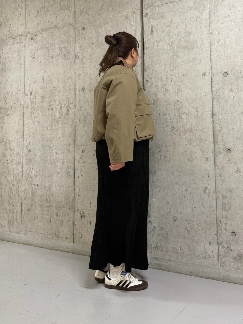 グリーン系のブルゾン、ブラック系のワンピースを着用したレディースの冬コーディネートの2枚目の写真