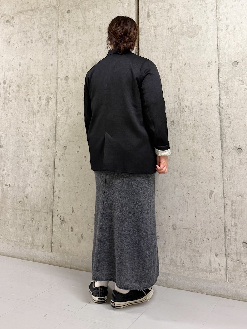 ブラック系のその他アウター、ホワイト系のTシャツ/カットソー、グレー系のスカートを着用したレディースの秋コーディネートの2枚目の写真
