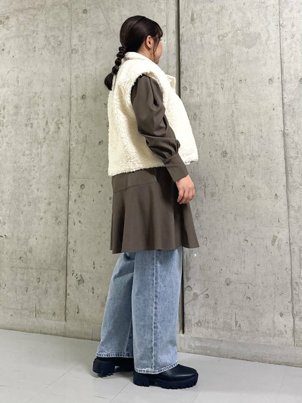 ブルー系のデニムパンツ、ブラック系のブーツ、ホワイト系のその他アウターを着用したレディースの秋コーディネートの2枚目の写真