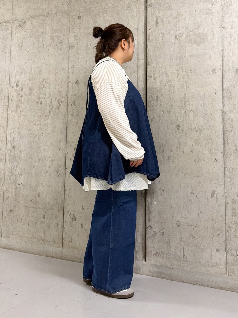 ホワイト系のニット/セーター、ブルー系のワンピース、ブルー系のデニムパンツを着用したレディースの春コーディネートの2枚目の写真