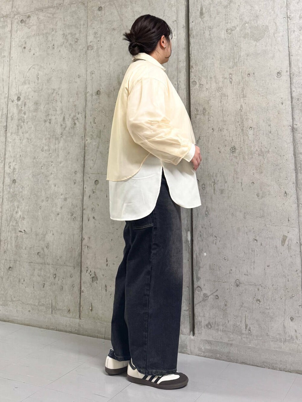 ブラック系のデニムパンツ、ベージュ系のシャツ/ブラウスを着用したレディースの春コーディネートの2枚目の写真
