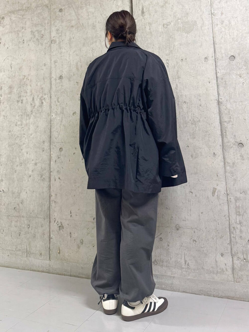 グレー系のその他パンツ、ブラック系のナイロンジャケット、ピンク系のTシャツ/カットソーを着用したレディースの春コーディネートの4枚目の写真