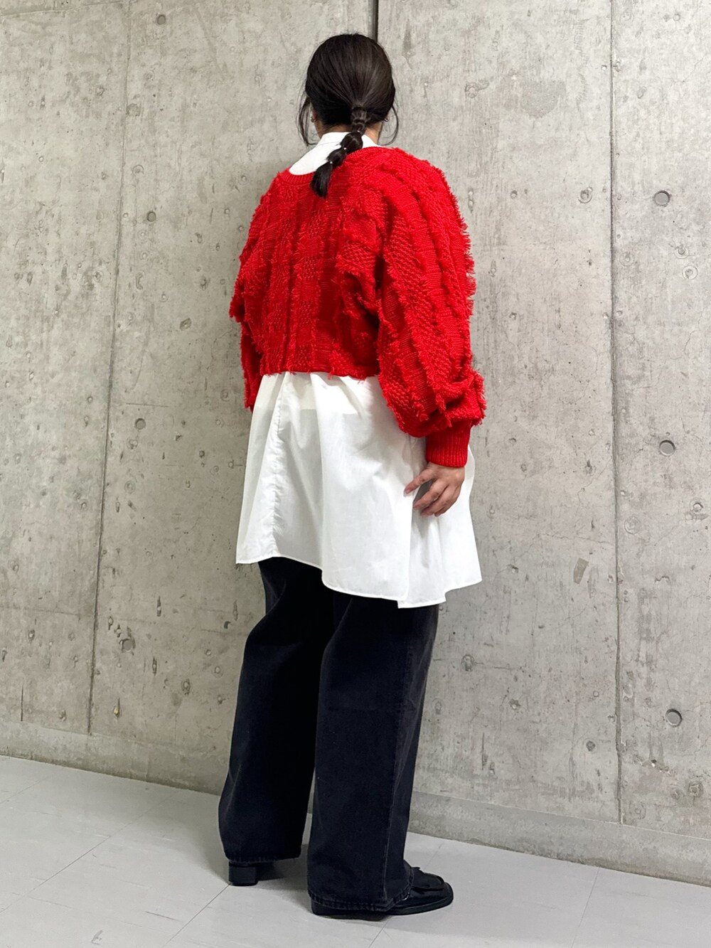 レッド系のカーディガン/ボレロ、ホワイト系のワンピース、ブラック系のデニムパンツを着用したレディースの冬コーディネートの3枚目の写真