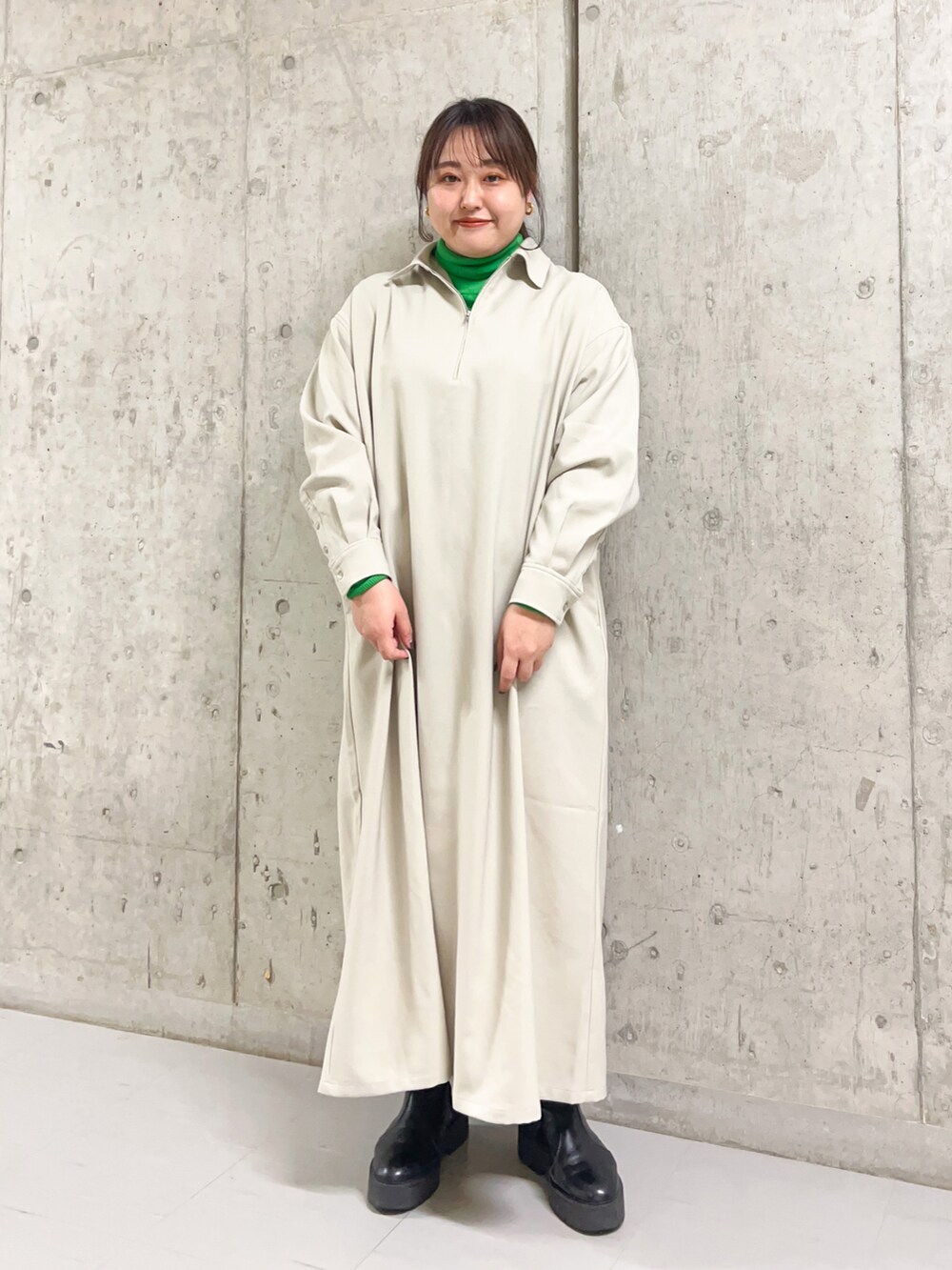 グリーン系のニット/セーター、グレー系のその他アウター、グレー系のワンピースを着用したレディースの冬コーディネートの2枚目の写真