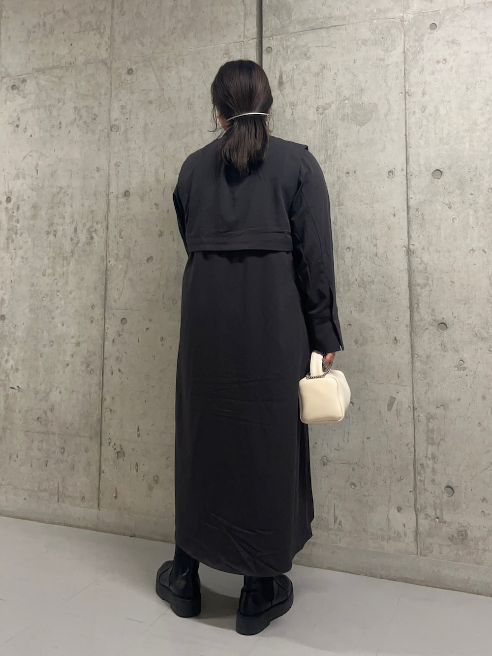 グレー系のワンピース、ホワイト系のハンドバッグを着用したレディースの秋コーディネートの3枚目の写真