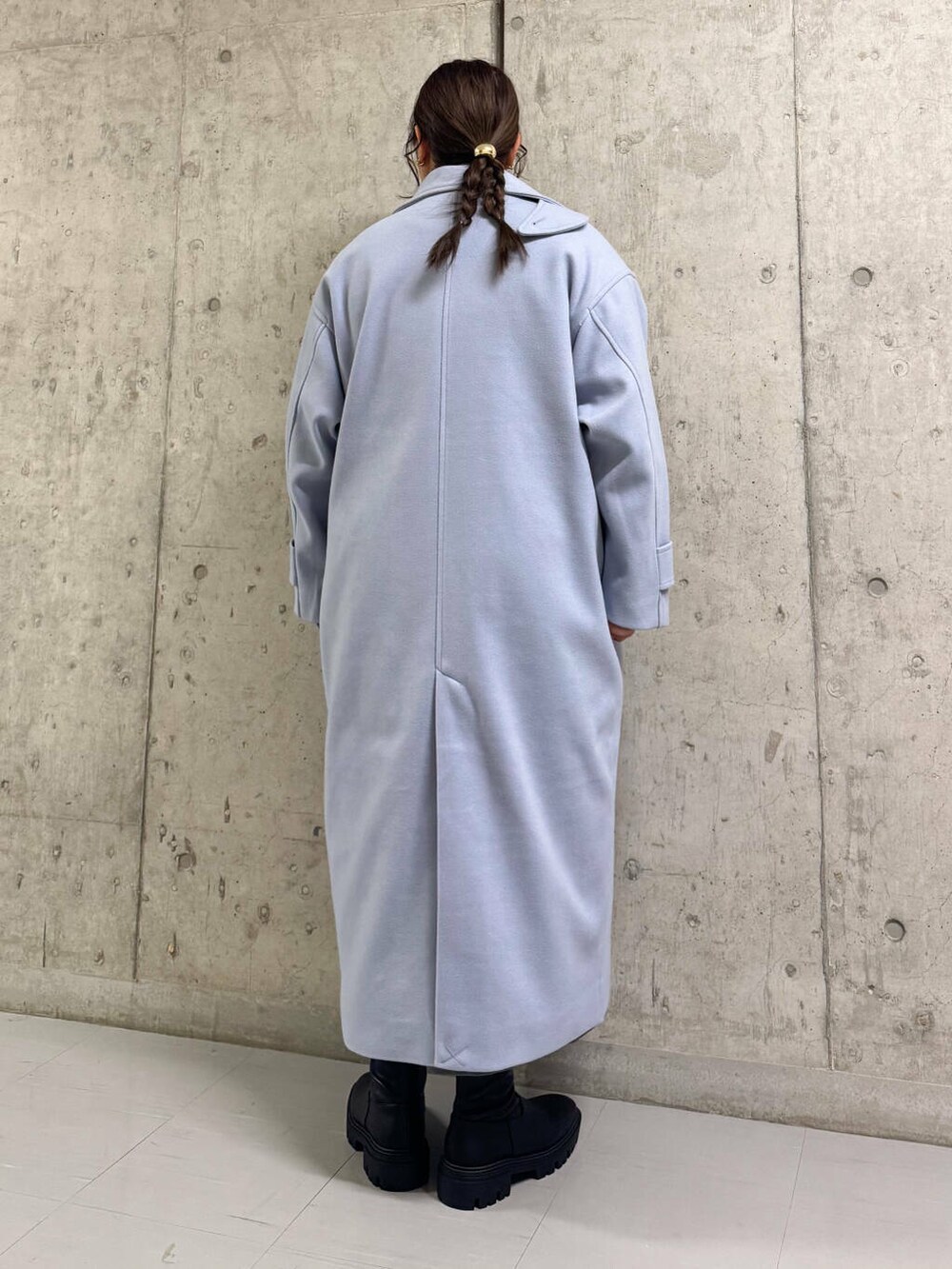 ブルー系のステンカラーコート、ブラック系のブーツ、グレー系のワンピースを着用したレディースの冬コーディネートの4枚目の写真