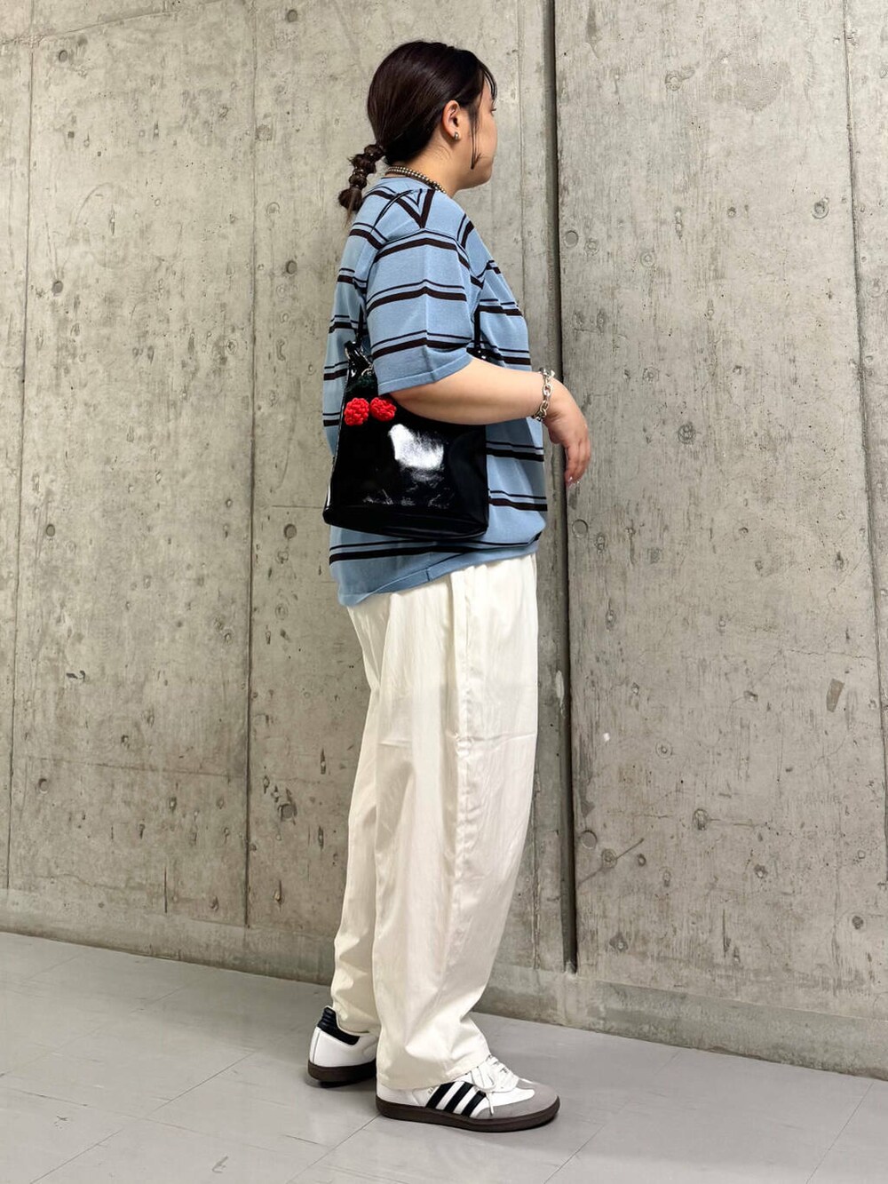 ブラック系のショルダーバッグ、ホワイト系のその他パンツ、ブルー系のニット/セーターを着用したレディースの春コーディネートの2枚目の写真