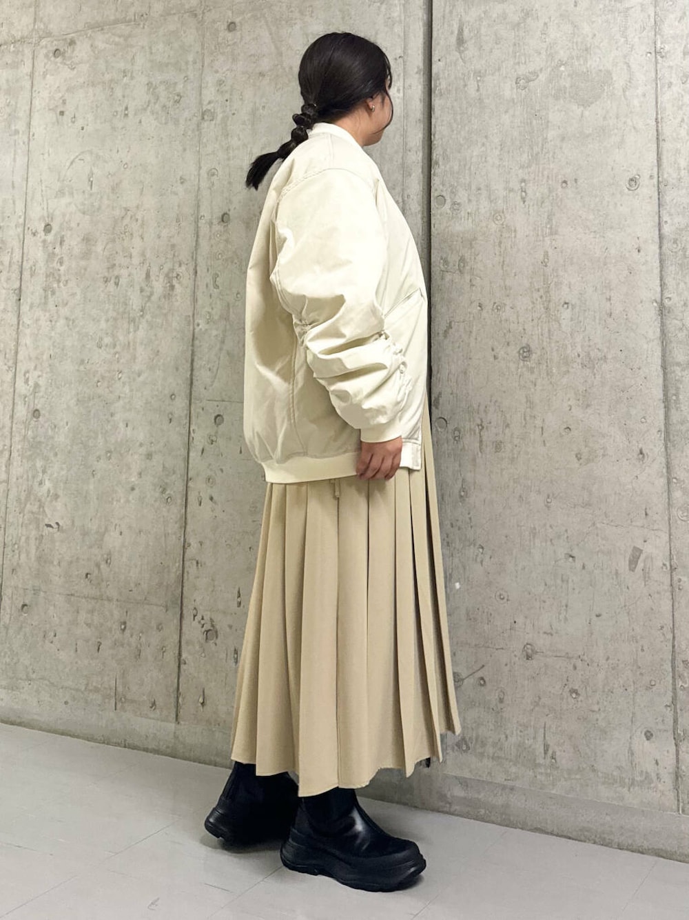 ブラック系のブーツ、ホワイト系のMA-1、ベージュ系のワンピースを着用したレディースの秋コーディネートの2枚目の写真