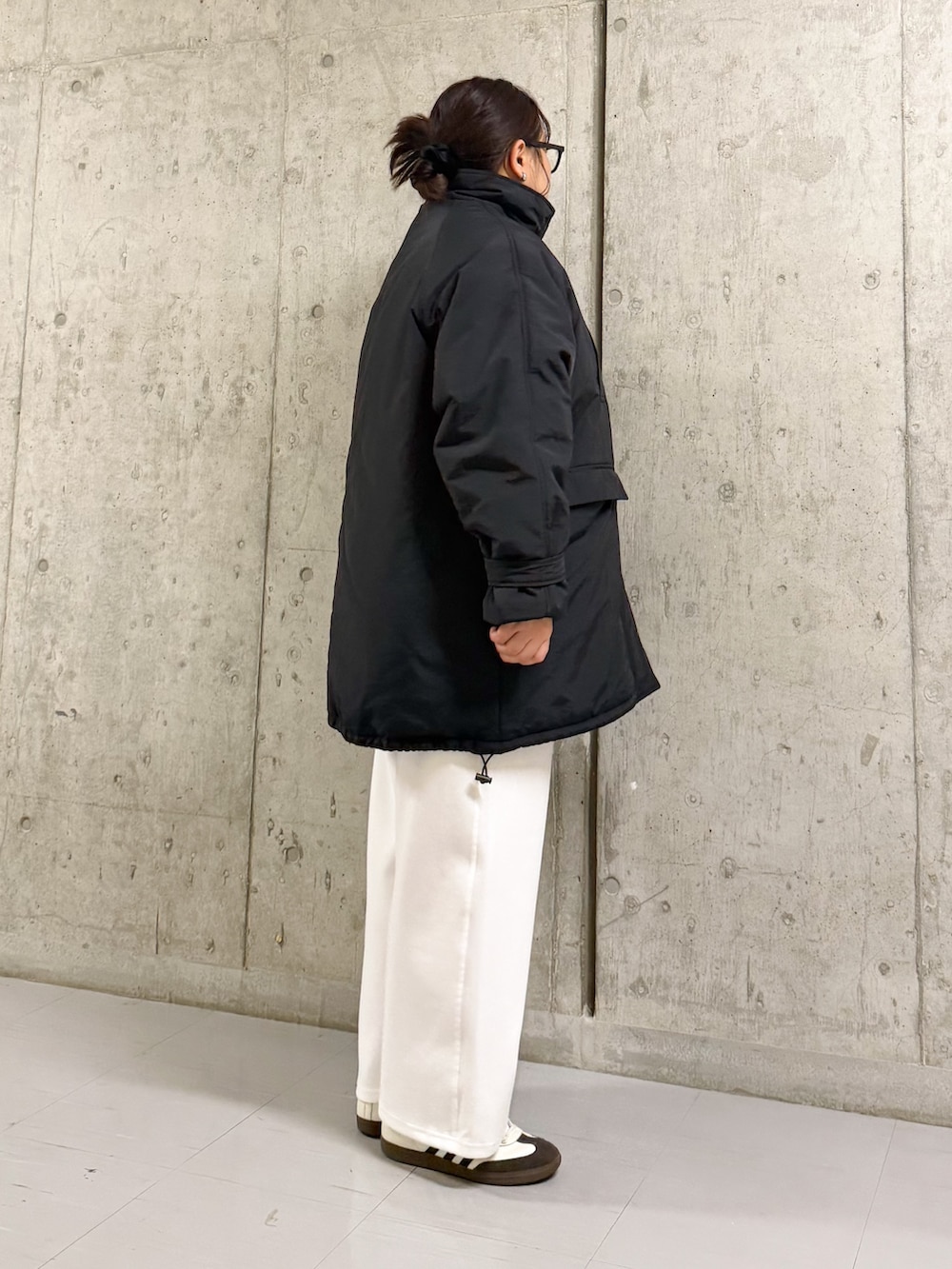 ホワイト系のその他パンツ、ブラック系のダウンジャケット/コート、ブラック系のメガネを着用したレディースの冬コーディネートの2枚目の写真