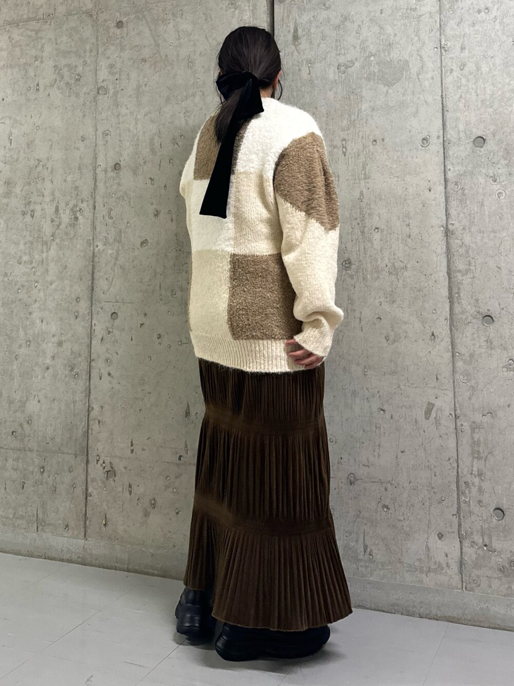 ベージュ系のニット/セーター、ブラウン系のワンピース、ブラック系のブーツを着用したレディースの冬コーディネートの2枚目の写真