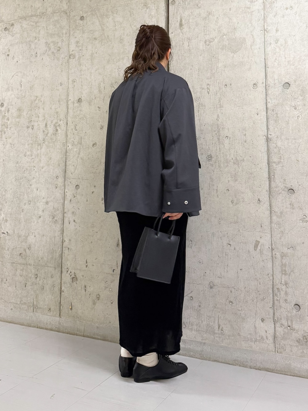 グレー系のその他アウター、ブラック系のワンピース、ブラック系のハンドバッグを着用したレディースの春コーディネートの3枚目の写真