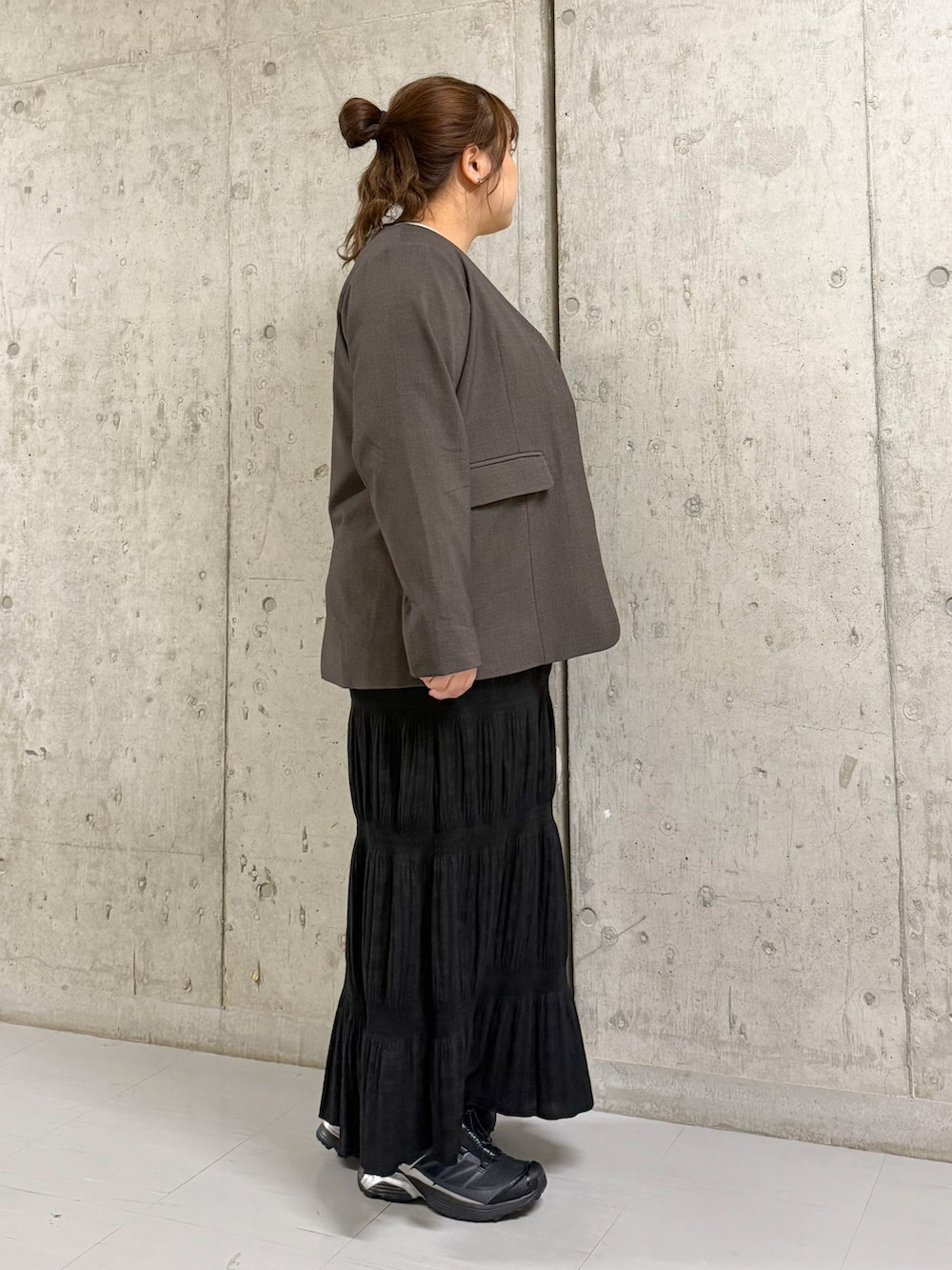 ブラック系のセットアップ、ブラウン系のノーカラージャケット、ベージュ系のタンクトップを着用したレディースの春コーディネートの2枚目の写真