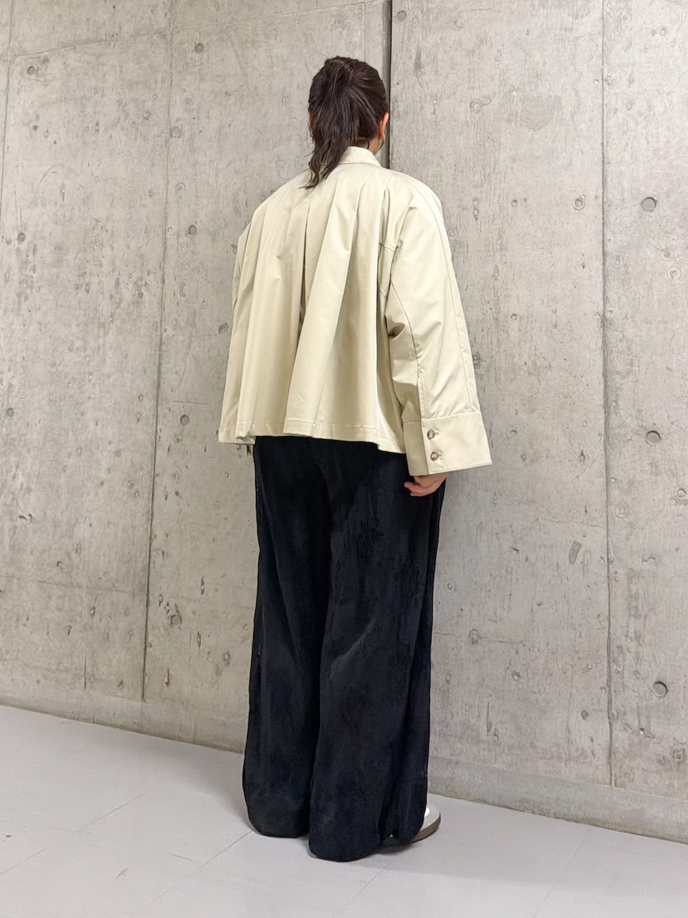 グレー系のステンカラーコート、ブラック系のその他パンツを着用したレディースの冬コーディネートの2枚目の写真