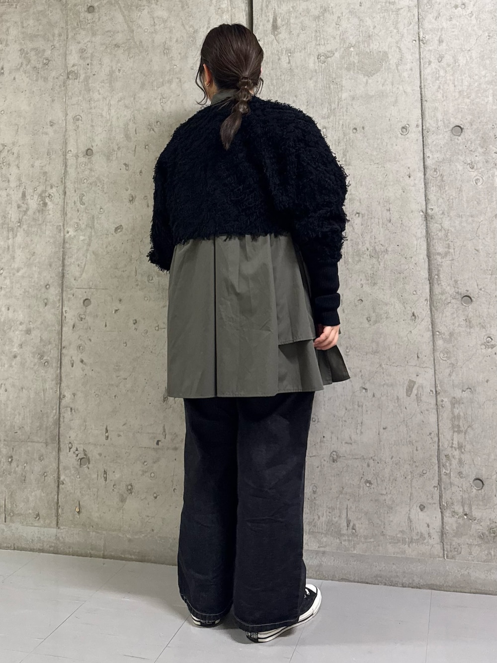 ブラック系のカーディガン/ボレロ、グレー系のワンピース、ブラック系のデニムパンツを着用したレディースの冬コーディネートの2枚目の写真