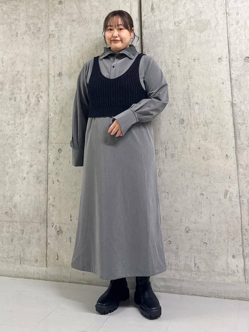 ブルー系のステンカラーコート、ブラック系のブーツ、グレー系のワンピースを着用したレディースの冬コーディネートの2枚目の写真