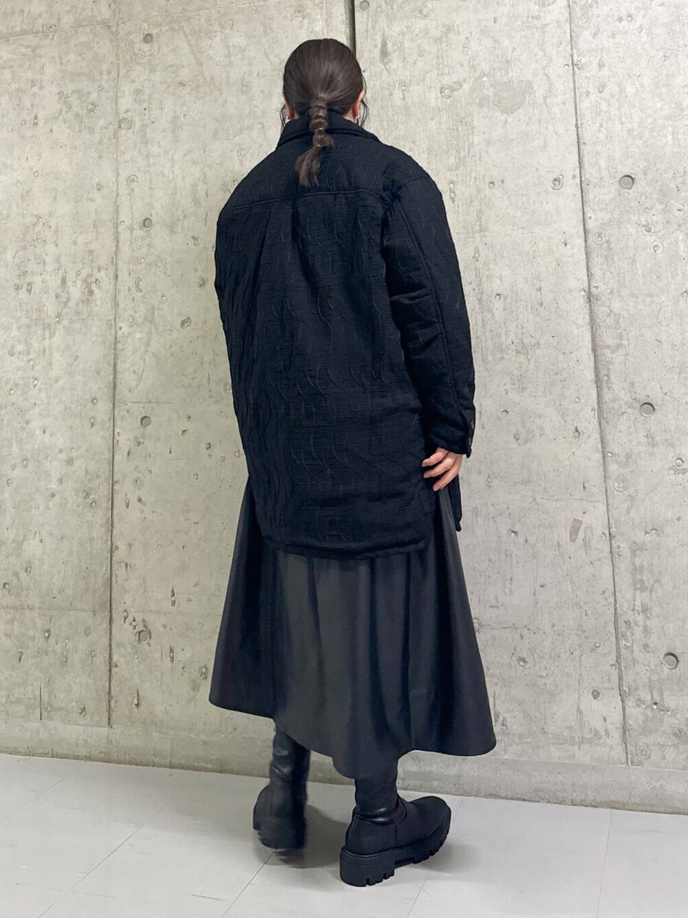 ブラック系のブーツ、ブラック系のスカート、ホワイト系のニット/セーターを着用したレディースの秋コーディネートの4枚目の写真