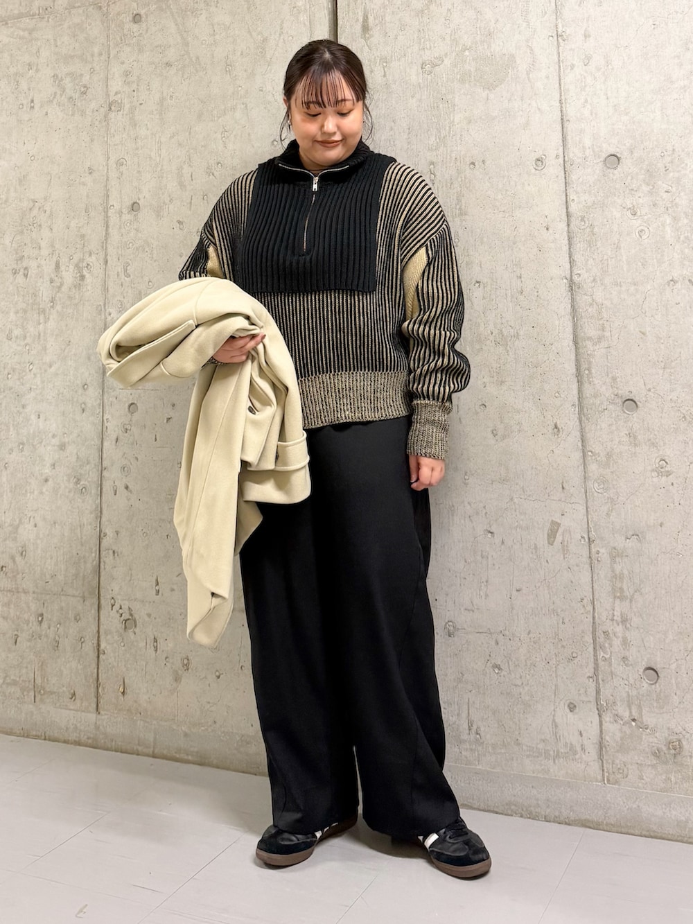 ベージュ系のその他アウター、ブラック系のニット/セーター、ブラック系のその他パンツを着用したレディースの冬コーディネートの2枚目の写真