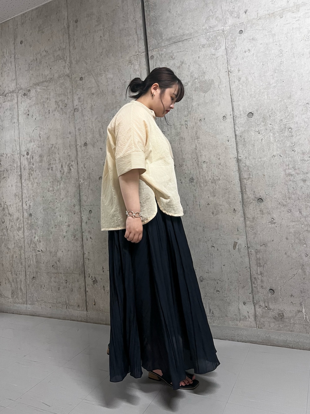 ベージュ系のシャツ/ブラウス、ブルー系のスカート、ブラック系のサンダルを着用したレディースの夏コーディネートの2枚目の写真