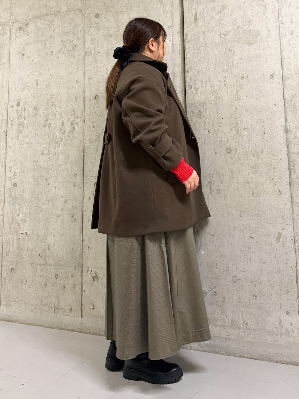 ブラウン系のその他アウター、レッド系のニット/セーター、ブラウン系のワンピースを着用したレディースの冬コーディネートの2枚目の写真