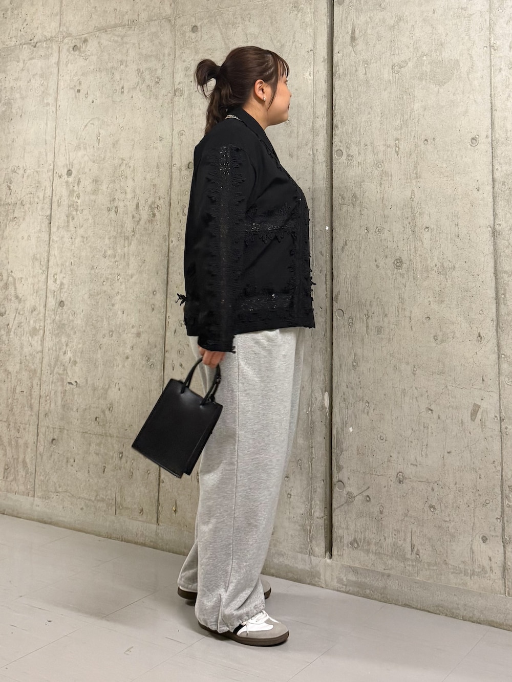 ブラック系のシャツ/ブラウス、グレー系のその他パンツ、ブラック系のハンドバッグを着用したレディースの春コーディネートの2枚目の写真