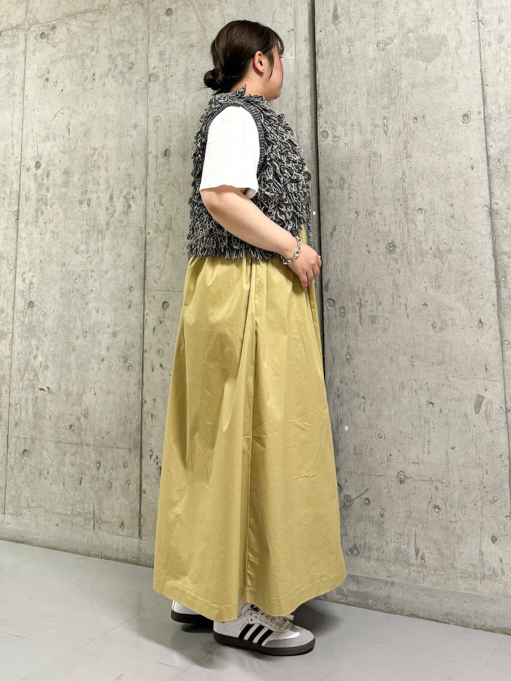 ブラック系のベスト、ベージュ系のワンピース、ホワイト系のTシャツ/カットソーを着用したレディースの夏コーディネートの2枚目の写真