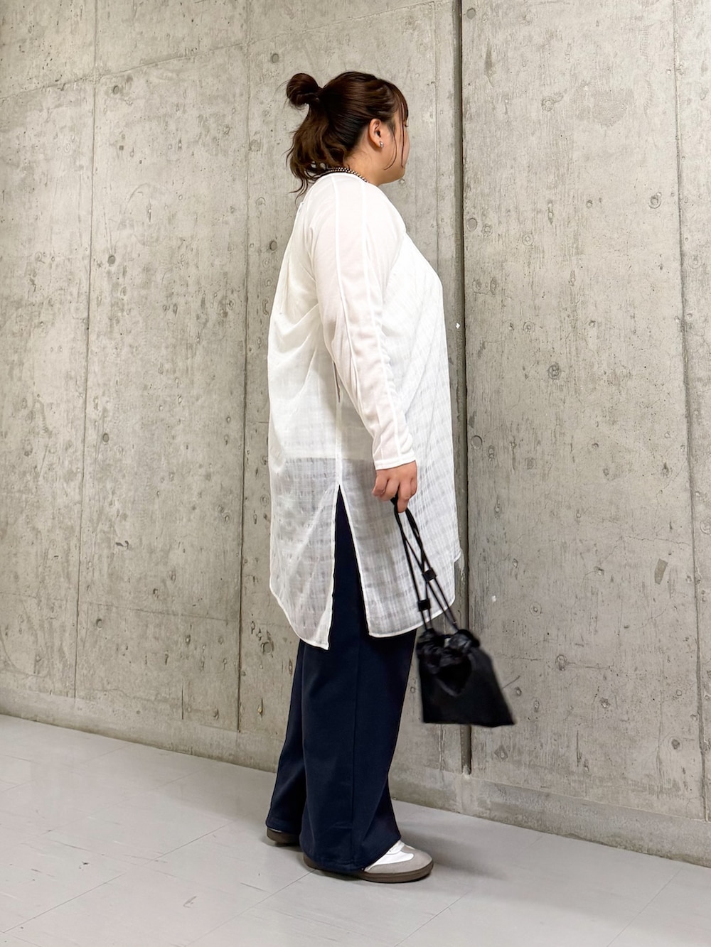 ブラック系のショルダーバッグ、ブルー系のその他パンツ、ホワイト系のその他トップスを着用したレディースの春コーディネートの2枚目の写真