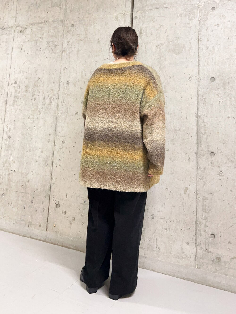 ベージュ系のタンクトップ、ブラウン系のカーディガン/ボレロ、ブラック系のパンツを着用したレディースの秋コーディネートの3枚目の写真