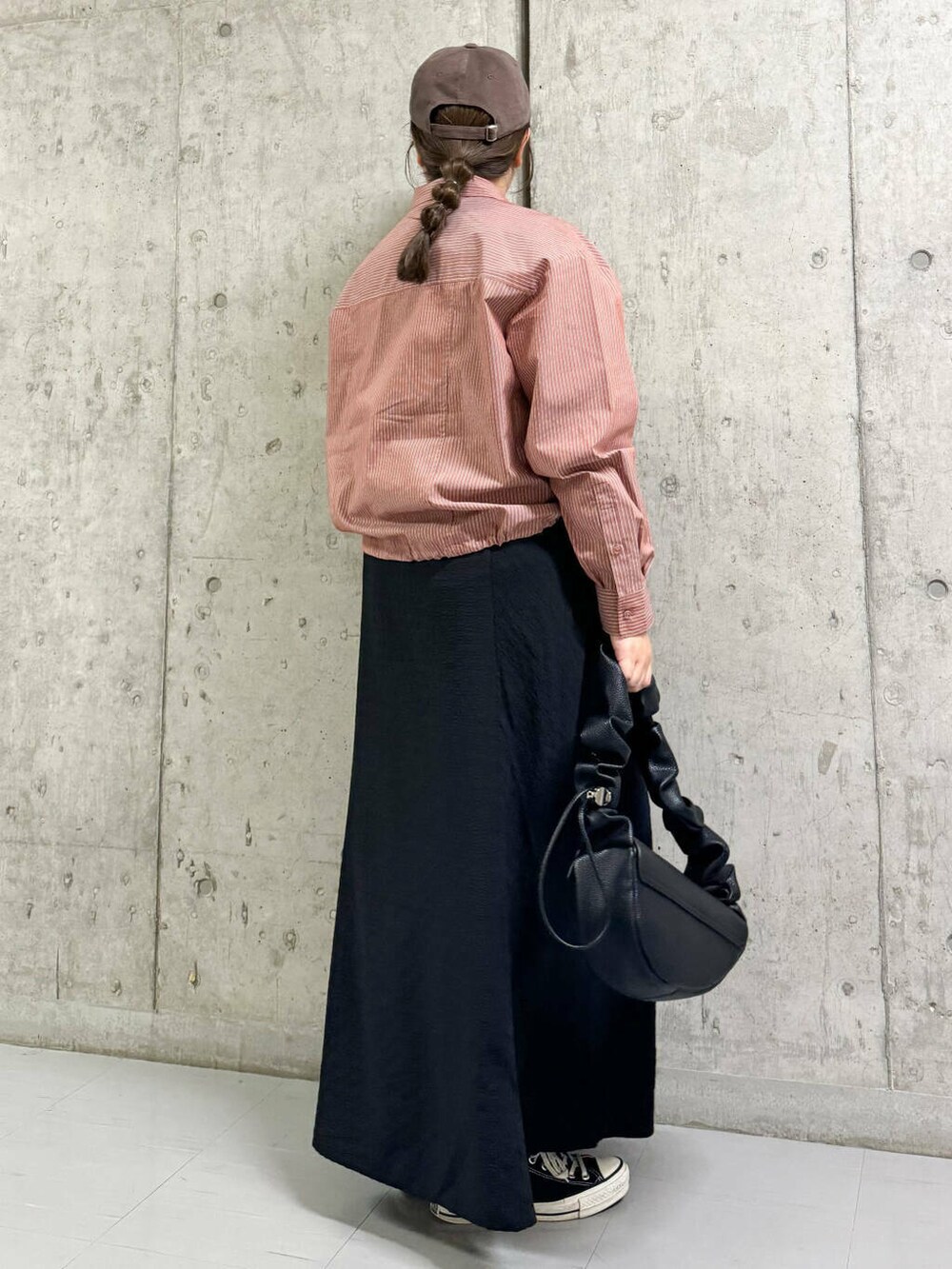 ブラック系のワンピース、ブラック系のハンドバッグ、レッド系のシャツ/ブラウスを着用したレディースの秋コーディネートの3枚目の写真