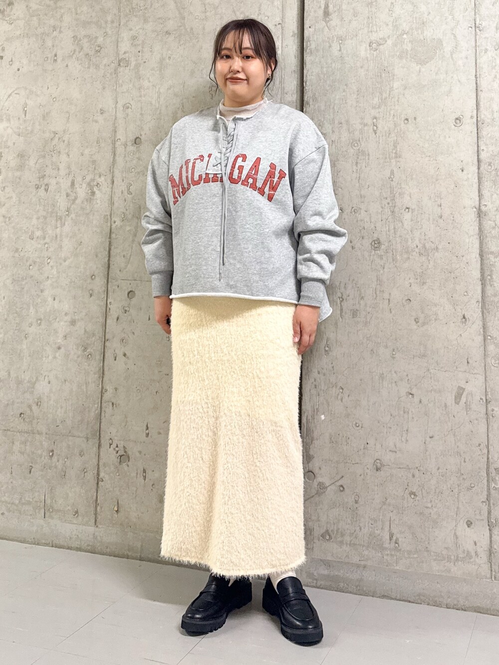 ブルー系のステンカラーコート、グレー系のスウェット、ホワイト系のスカートを着用したレディースの冬コーディネートの2枚目の写真