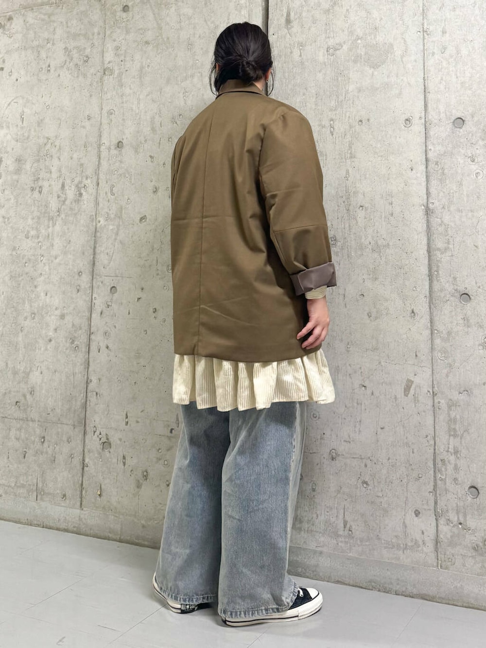 ベージュ系のワンピース、ブルー系のデニムパンツ、ブラウン系のその他アウターを着用したレディースの秋コーディネートの2枚目の写真