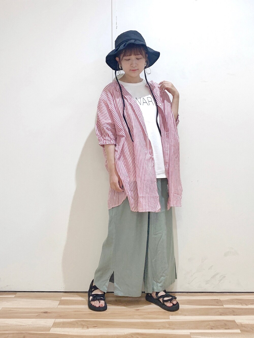 ブラック系のサンダル、ピンク系のシャツ/ブラウス、ホワイト系のTシャツ/カットソーを着用したレディースの夏コーディネートの2枚目の写真